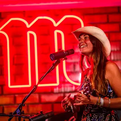 Leyla singt live auf einer Bühne vor rotem Neonlicht
