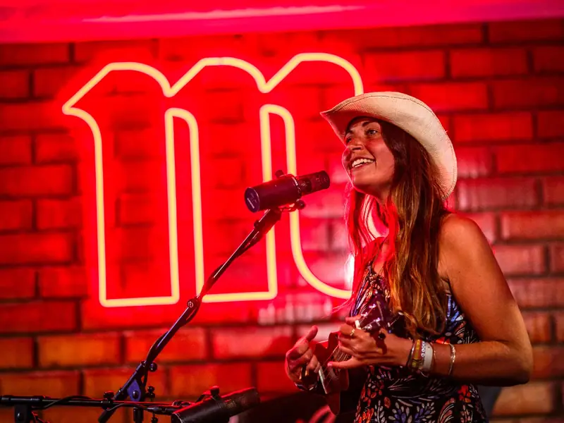 Leyla singt live auf einer Bühne vor rotem Neonlicht